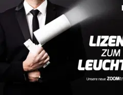 Werbegrafik von DOTLUX mit dem Slogan 'Lizenz zum Leuchten' und einem Mann im Anzug, der eine Leuchte wie ein Gadget hält, für die neue ZOOMtrack-Serie.